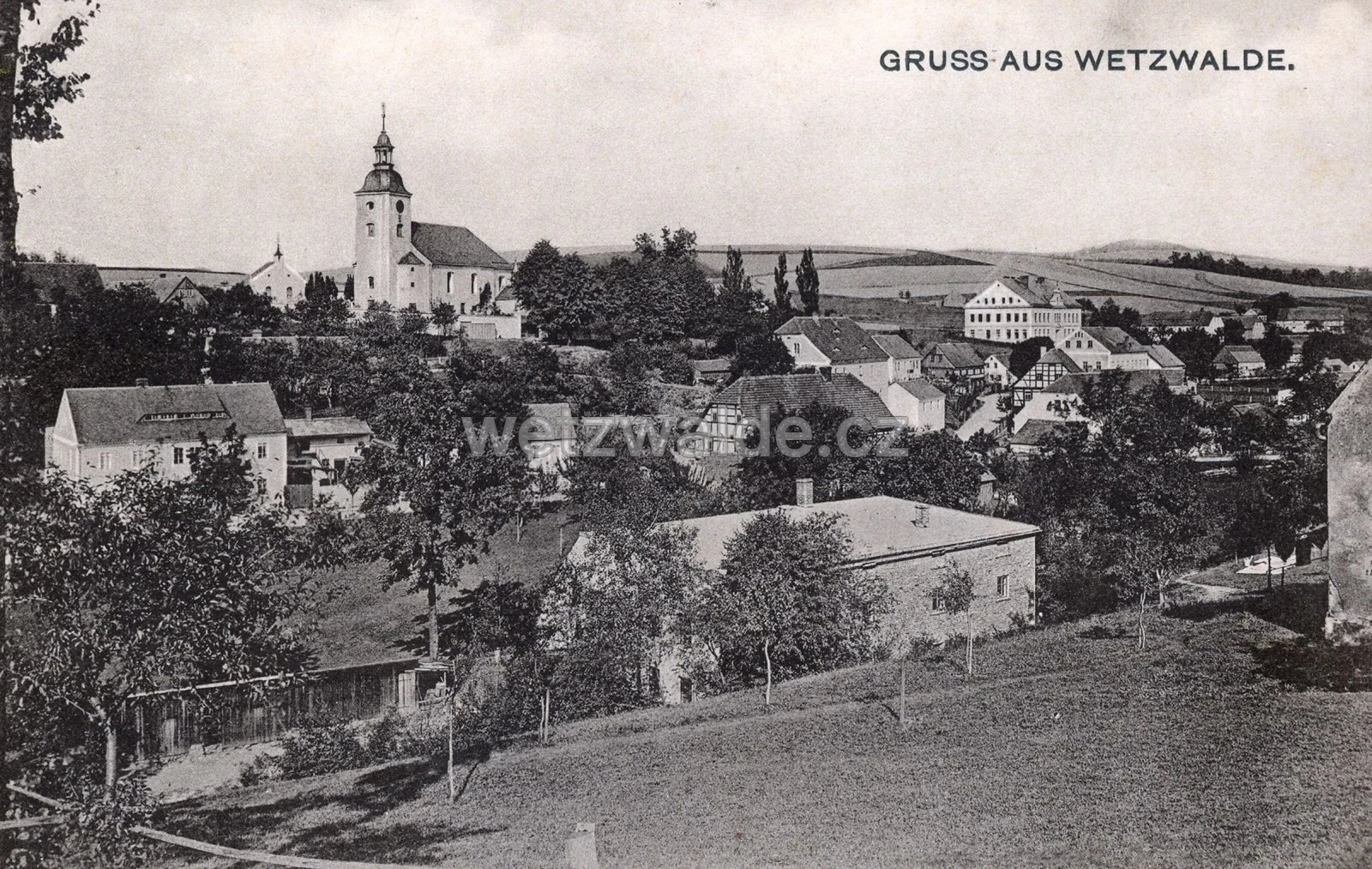 Dobová pohlednice vsi s kostelem před rokem 1945.